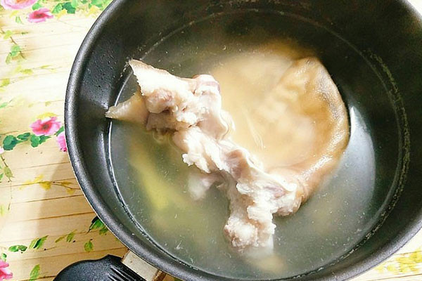 Hình ảnh tai heo đang được luộc chín đều để làm tai heo ngâm mắm