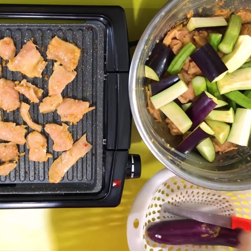 Những miếng vú heo tẩm ướp đậm đà đang được nướng trên bếp hồng