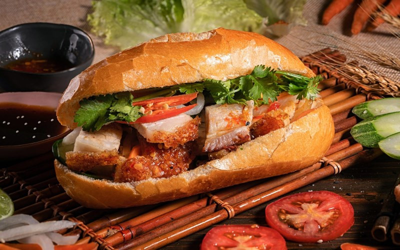 Ổ bánh mì heo quay nhân thịt giòn rụm và rau dưa